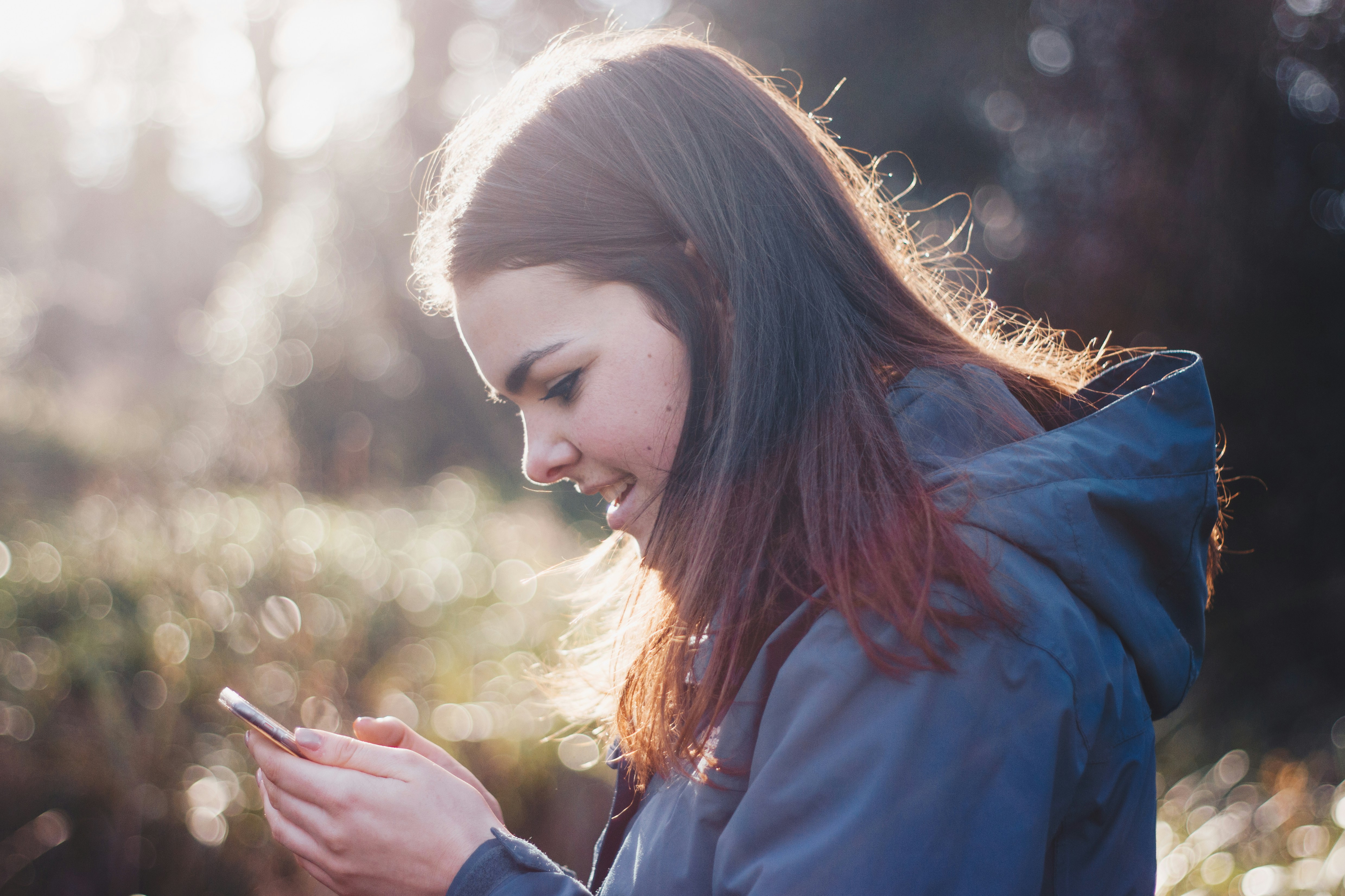 Happy girl using her phone to look up when the next John Abbott BioBlitz is. 